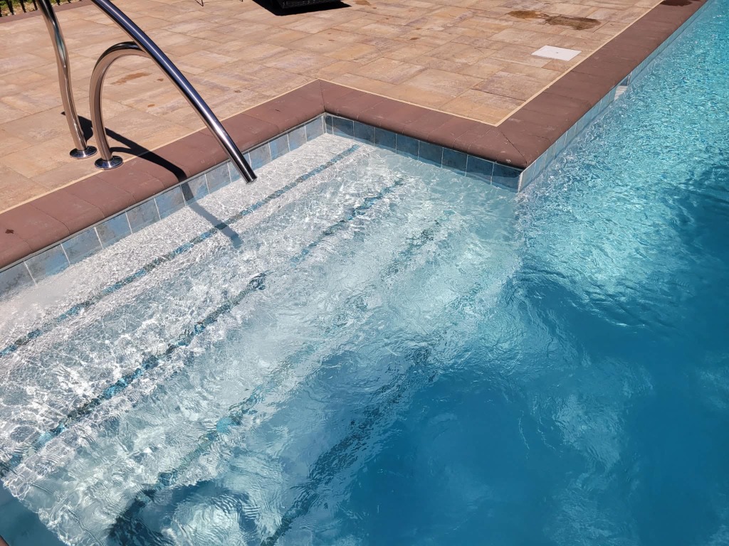 Pool spa with sun shelf and steps